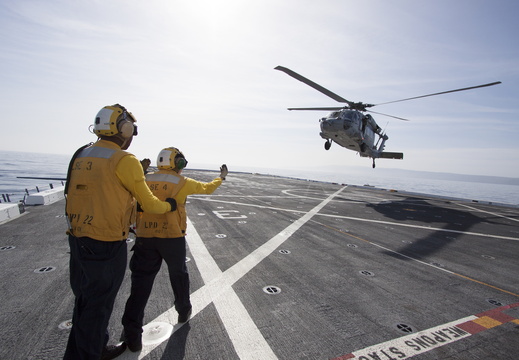 Navy Personnel monitor a helicopter landing